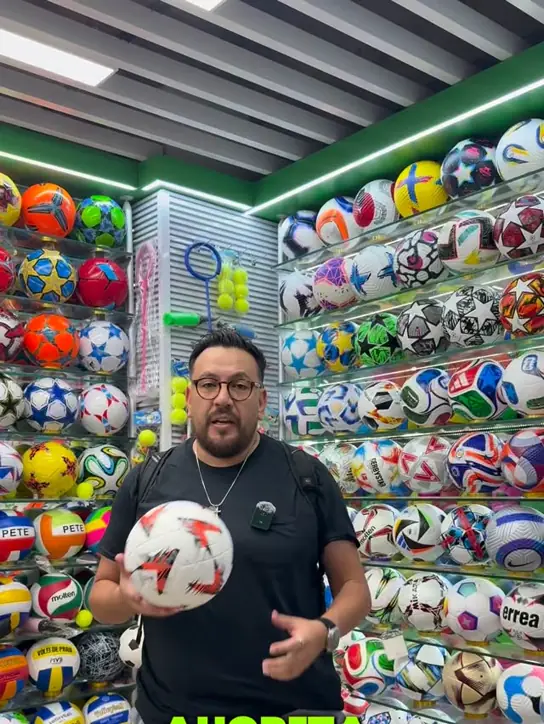 Showroom de un fabricante chino con estanterías llenas de balones de fútbol, básquet y voleibol